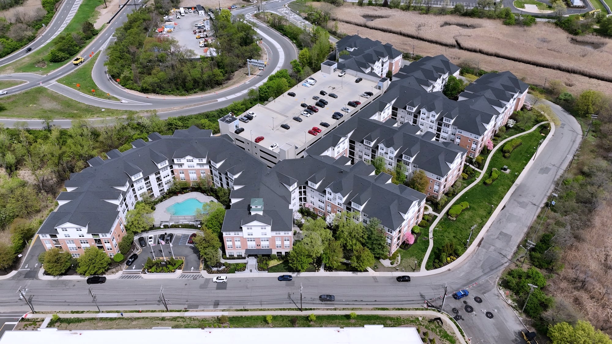 Aerial view of large apartment complex with dark shingle roofs